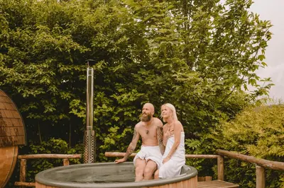 a man and a woman sitting in a hot tub at Villa Gloria in Soprabolzano
