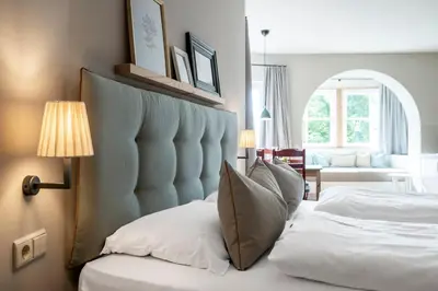 a bedroom with a bed with a blue padded headboard at Villa Gloria in Soprabolzano
