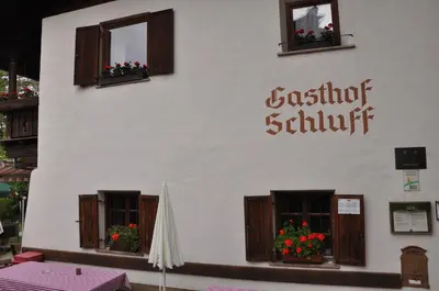 a building with windows and a sign that reads architect submit at Gasthof Schluff in Soprabolzano