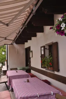 two tables with red and white checkered sheets on a patio at Gasthof Schluff in Soprabolzano