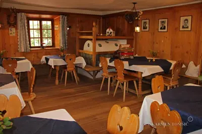 a dining room with tables and chairs and a tub at Gasthof Schluff in Soprabolzano