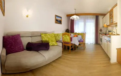 a living room with a couch and a table at Villa Artic Apartments in Campitello di Fassa