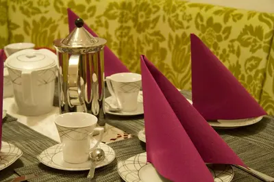 a table with purple napkins on top of a table at Villa Artic Apartments in Campitello di Fassa