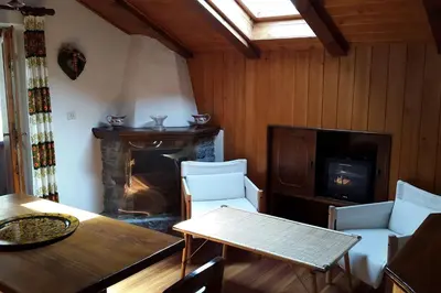 a living room with a table and a fireplace at Mansarda a San Vito di Cadore in San Vito di Cadore