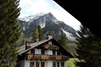 a building with a snow covered mountain in the background at Mansarda a San Vito di Cadore in San Vito di Cadore