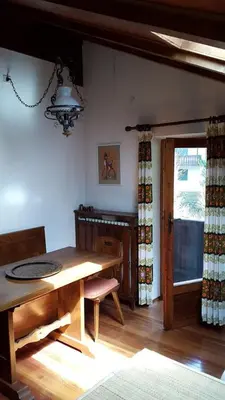 a dining room with a wooden table and a window at Mansarda a San Vito di Cadore in San Vito di Cadore