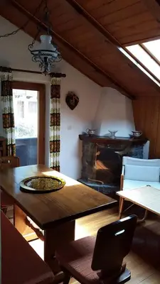 a dining room with a table and a fireplace at Mansarda a San Vito di Cadore in San Vito di Cadore