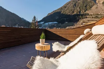 a balcony with a bench and a table with a plant at Appartement Wiere in Molini di Tures