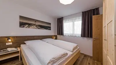 a bedroom with a large white bed and a window at Appartement Wiere in Molini di Tures
