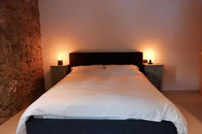 a bedroom with a large bed with two night stands at Appartamenti La Rocia in Rocca Pietore