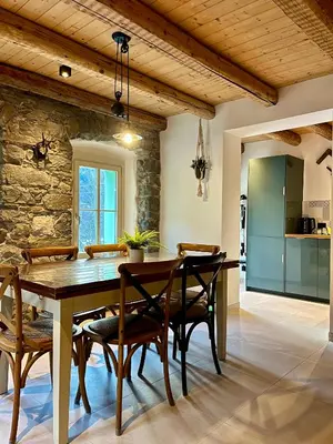 a kitchen and dining room with a wooden table and chairs at Appartamenti La Rocia in Rocca Pietore
