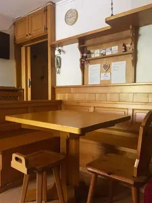 a wooden table and two chairs in a room at CASA VACANZE MIRAMONTI - appartamento con balcone con vista sulle Dolomiti in Borca di Cadore