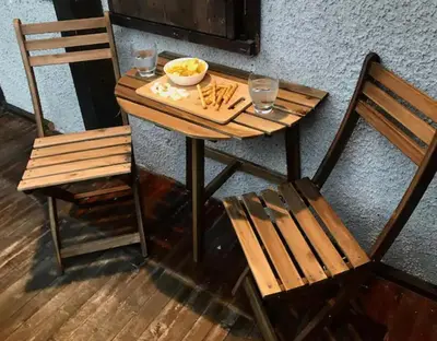 a wooden table with a bowl of food and two chairs at CASA VACANZE MIRAMONTI - appartamento con balcone con vista sulle Dolomiti in Borca di Cadore
