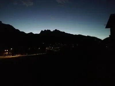 a view of a mountain at night with a city at CASA VACANZE MIRAMONTI - appartamento con balcone con vista sulle Dolomiti in Borca di Cadore
