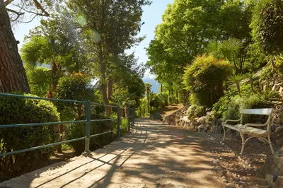 a path with a bench and trees and a fence at Appartment Larcher - Meinhard in Merano