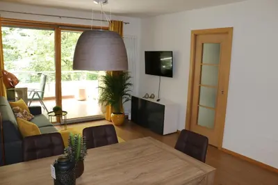 a living room with a dining table and a tv at Appartment Larcher - Meinhard in Merano