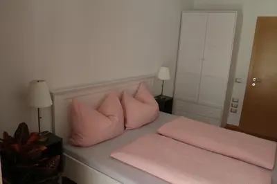 a bed with pink pillows on top of it at Appartment Larcher - Meinhard in Merano