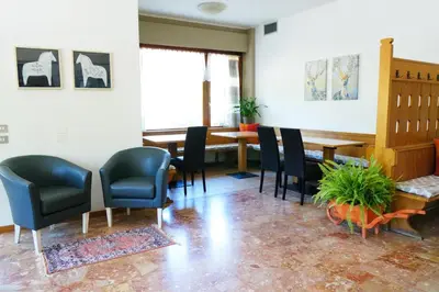 a restaurant with white tables and chairs and a kitchen at Villa Ombretta in Soraga