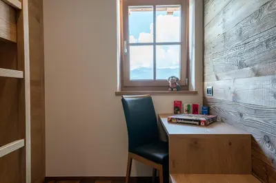 a room with a desk with a chair and a window at Rodererhof in Laion