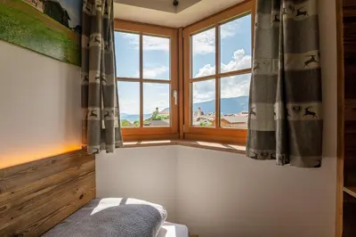 a bedroom with a window with a view of the mountains at Rodererhof in Laion