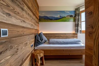a bed in a room with a wooden wall at Rodererhof in Laion