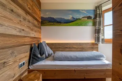 a bench in a room with a painting on the wall at Rodererhof in Laion