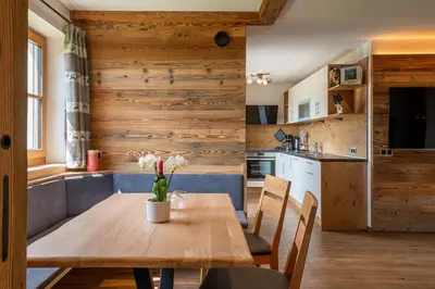a kitchen and dining room with a wooden table and chairs at Rodererhof in Laion