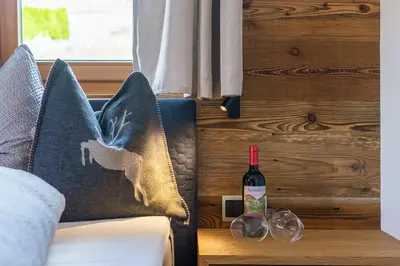 a bedroom with a bed with a bottle of wine at Rodererhof in Laion