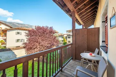 a balcony with a table and a view of a building at Glögglhof in Appiano sulla Strada del Vino