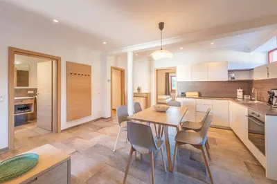 a kitchen and dining room with a wooden table and chairs at Glögglhof in Appiano sulla Strada del Vino