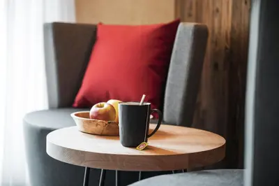 a cup of coffee and a bowl of apples on a table at Batacör - Natures Heartbeat in San Vigilio Di Marebbe