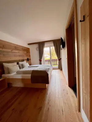 a bedroom with a large bed and a window at Garni Bergblick in Braies
