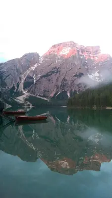 a boat on a lake in front of a mountain at Garni Bergblick in Braies