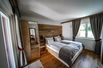 a bedroom with a bed and a large window at Garni Bergblick in Braies