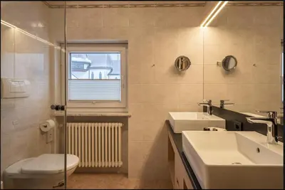 a bathroom with a sink and a toilet and a window at ARTEFUGIUM panoramico in Selva di Val Gardena