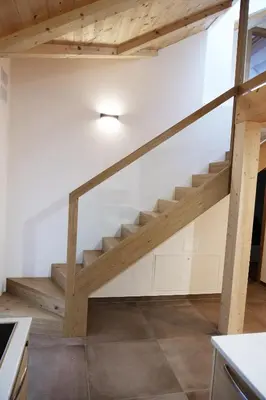 a staircase in a house with wooden beams at Alpine Home Fiemme in Predazzo