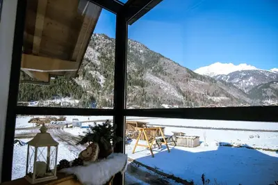 a view of a snowy mountain from a window at Alpine Home Fiemme in Predazzo