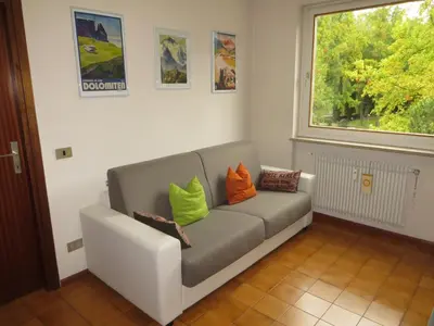 a living room with a couch with colorful pillows on it at Appartamento Panoramico Lungopassirio in Merano