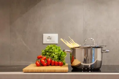 a cutting board with tomatoes and a pot on a stove at Apartment Hanni in Merano