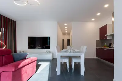 a living room with a white table and a red couch at Apartment Hanni in Merano