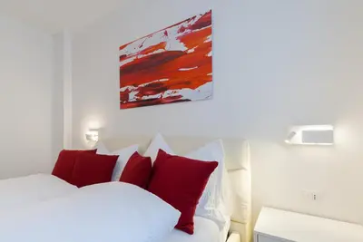 a bedroom with a white bed with red pillows at Apartment Hanni in Merano