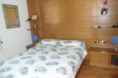 a bedroom with a bed with blue flowers on it at Casa Venturini in Moena