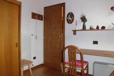 a room with a wooden door and a wooden chair at Casa Venturini in Moena