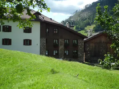 a building on the side of a grassy hill at Casa Venturini in Moena