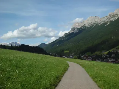 a path through a field with mountains in the background at Casa Venturini in Moena