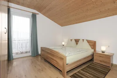 a bedroom with a bed and a large window at Traterhof-Spinges in Mühlbach