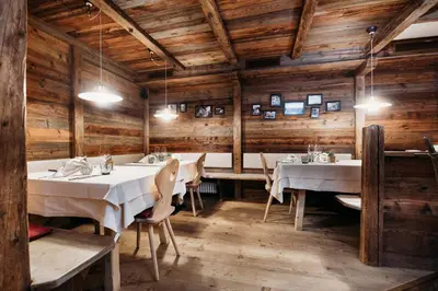a dining room with tables and chairs and wooden walls at Weingut & Genusshotel Spitalerhof Superior in Chiusa