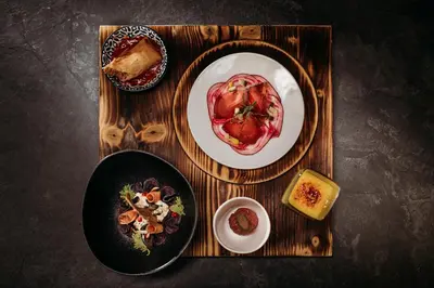 a wooden tray with two plates of food on it at Weingut & Genusshotel Spitalerhof Superior in Chiusa