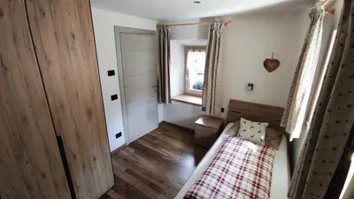 a small room with a bed and a window at Apartments Fabiola in Arabba