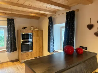 a kitchen with a table with red apples on it at Apartments Fabiola in Arabba
